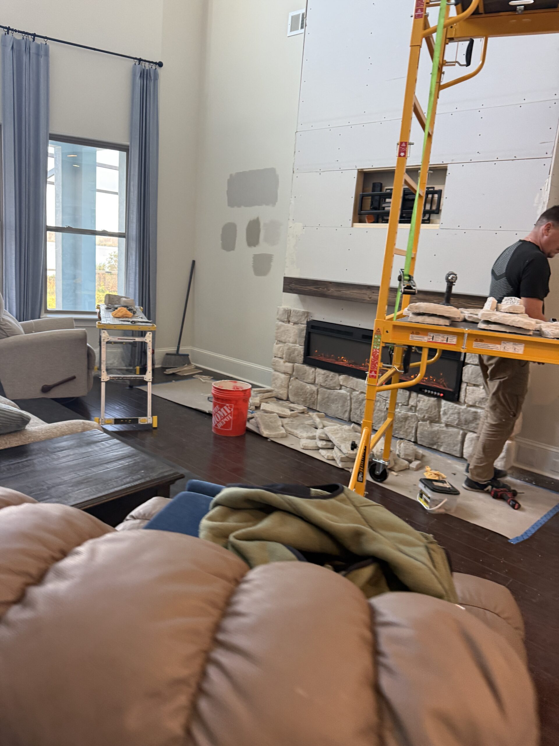 Natural limestone being installed on a tall custom fireplace wall in a Florida living room