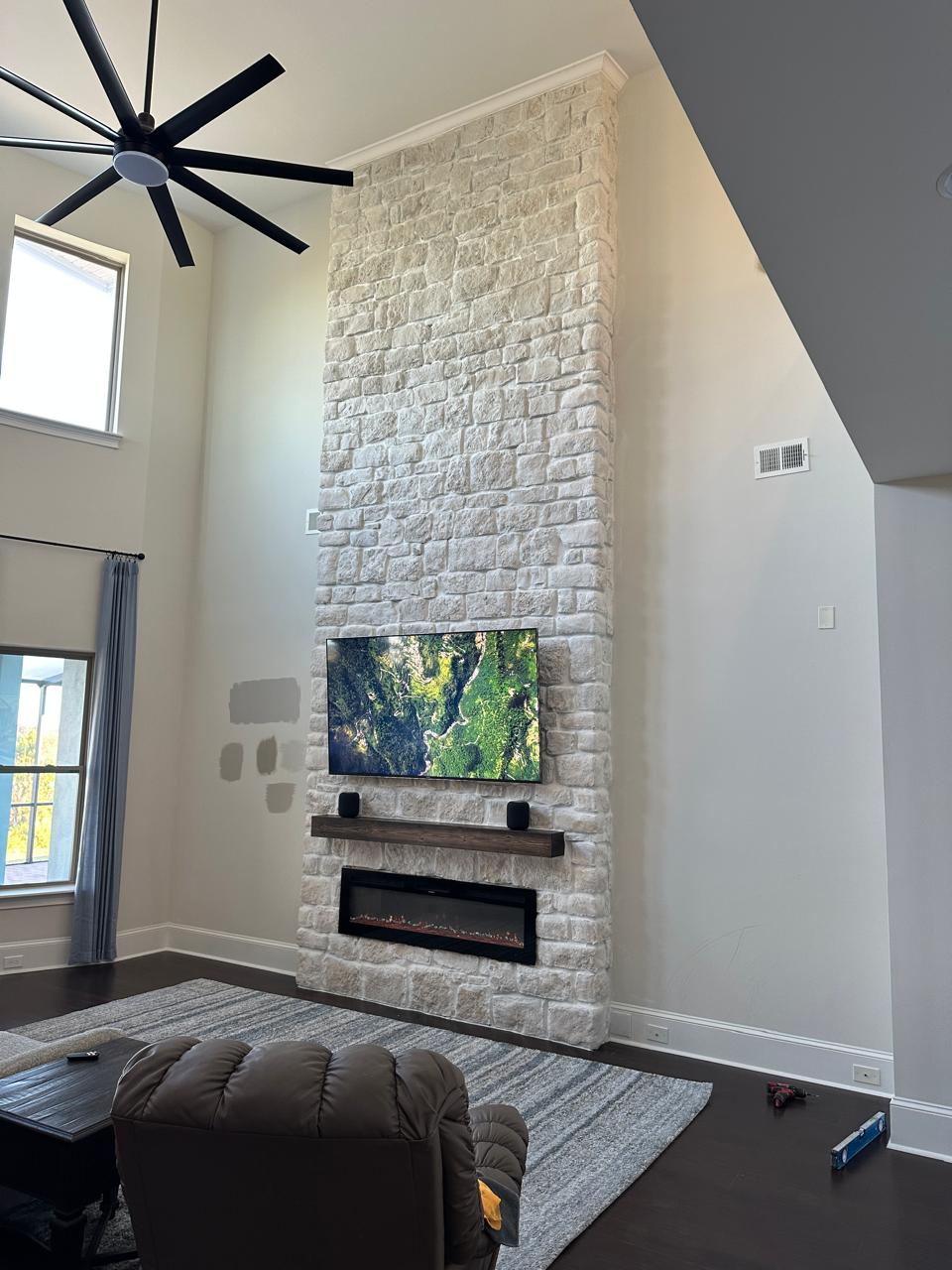 20-foot natural limestone custom fireplace wall in Florida Complete 20-foot natural limestone custom fireplace wall with TV and handcrafted wood mantel in a Florida home